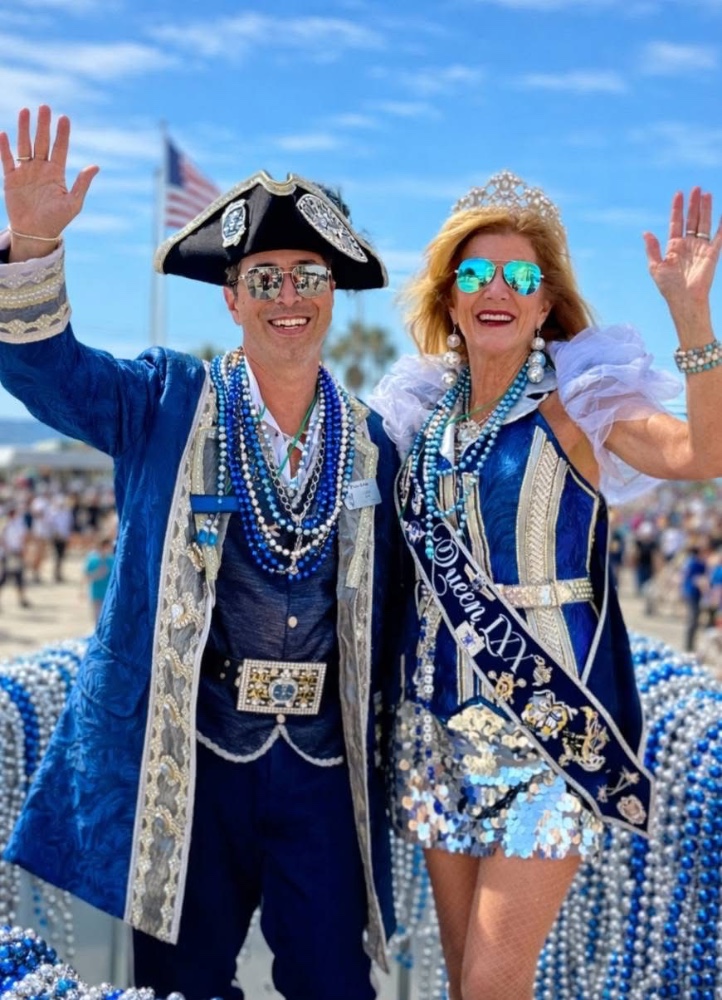Men and women in pirate costumes walking, waving and carrying flags